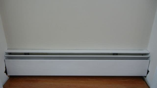 Painting a baseboard heating unit.